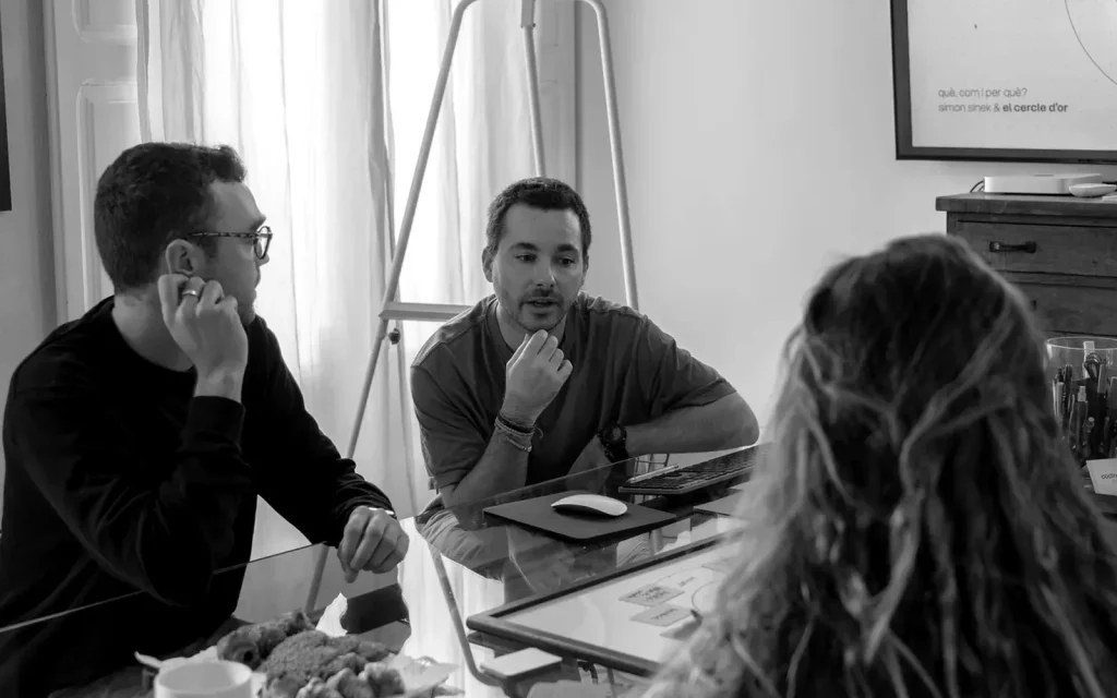 Membres de l'equip treballant junts a la taula de l'estudi.