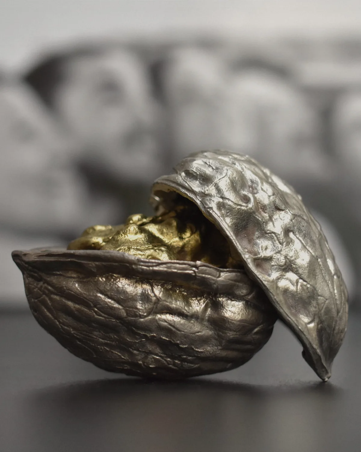 Una nou de plata oberta amb l'interior daurat, fotografiada com una peça de joieria.