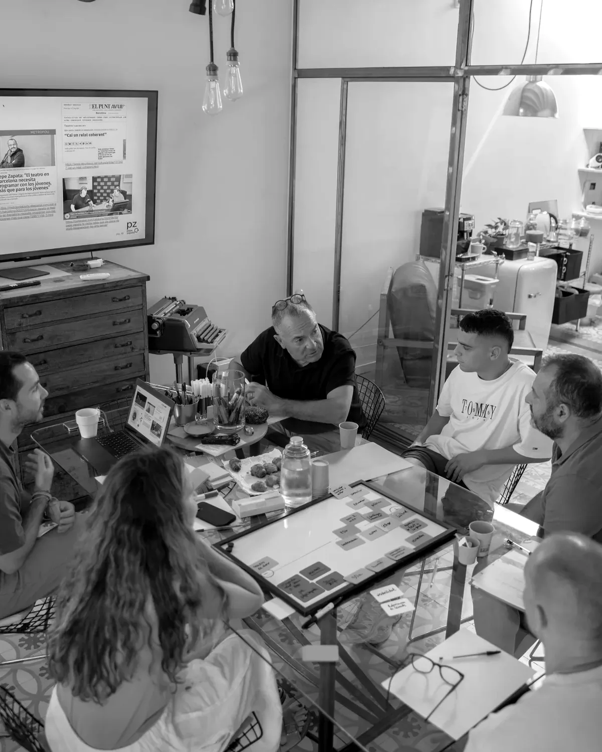 L'equip de l'estudi treballant junt al voltant de la taula.